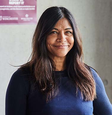 Head and shoulders of woman in blue top smiling