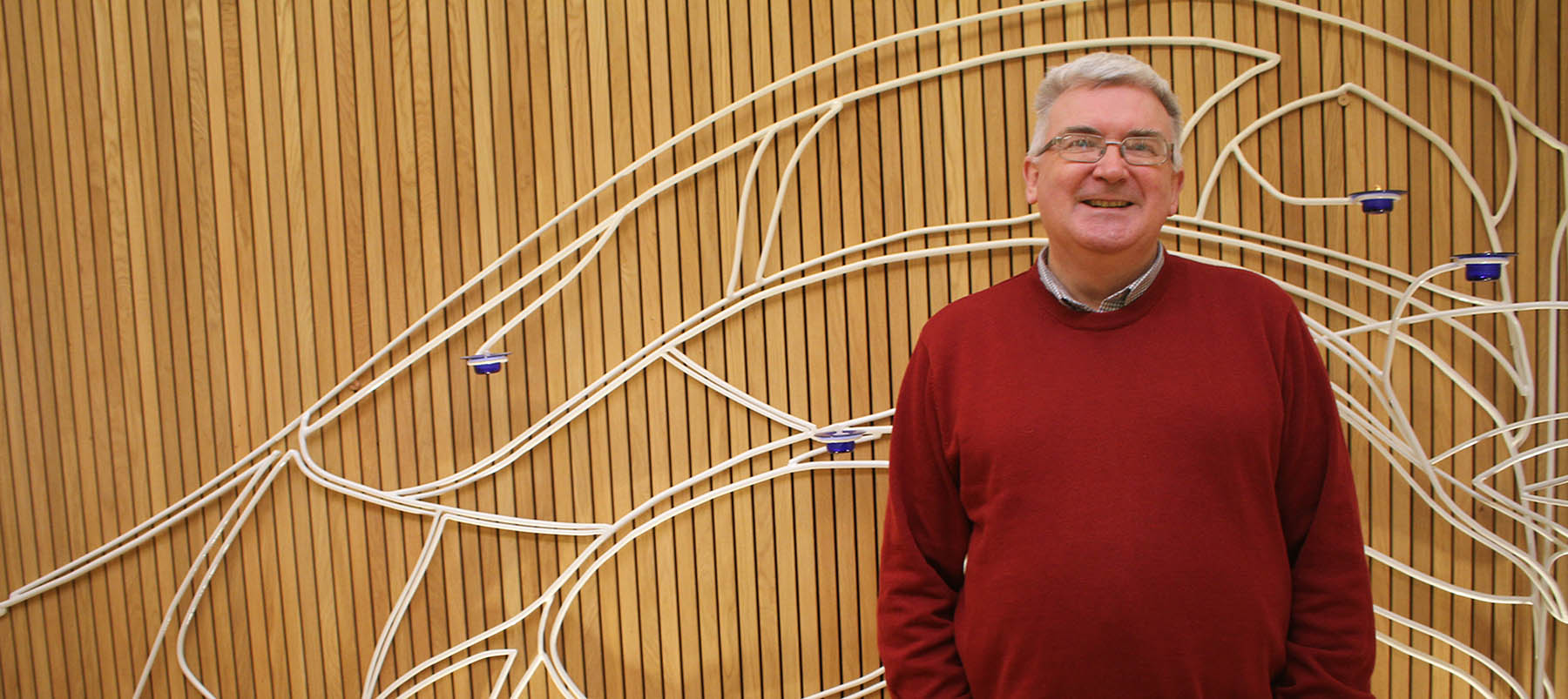 Terry Biddington, Dean of Spiritual Life headshot in red jumper