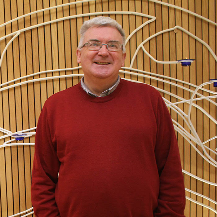 Terry Biddington, Dean of Spiritual Life headshot in red jumper