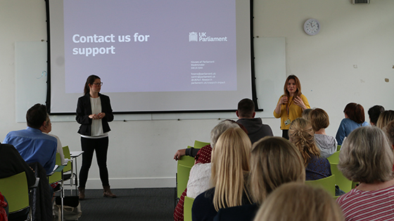 Two women giving UK Parliament presentation