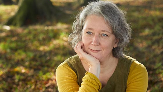 Claire sitting in the countryside with her chin in her hand