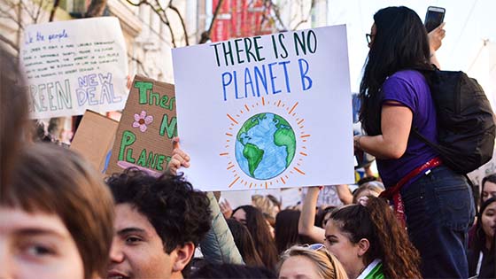 Climate Strike Protesters hold signs, visible one reads 