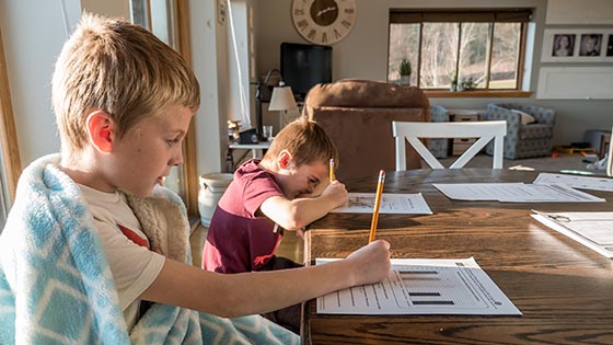 Two children doing school work at their kitchen table