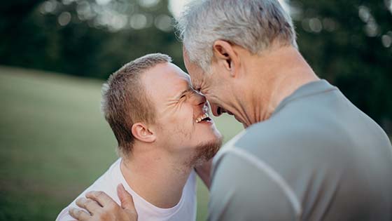 Two men talking to each other outside in a field