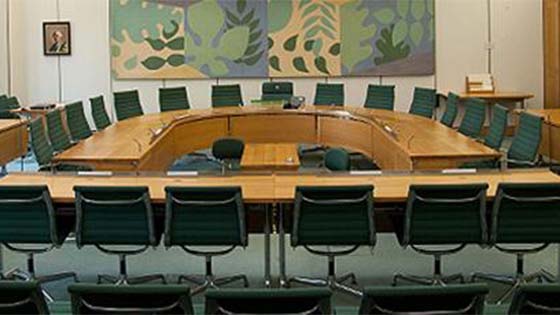 Empty conference table surrounded by chairs