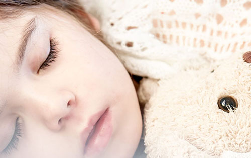 Child sleeping with teddy bear