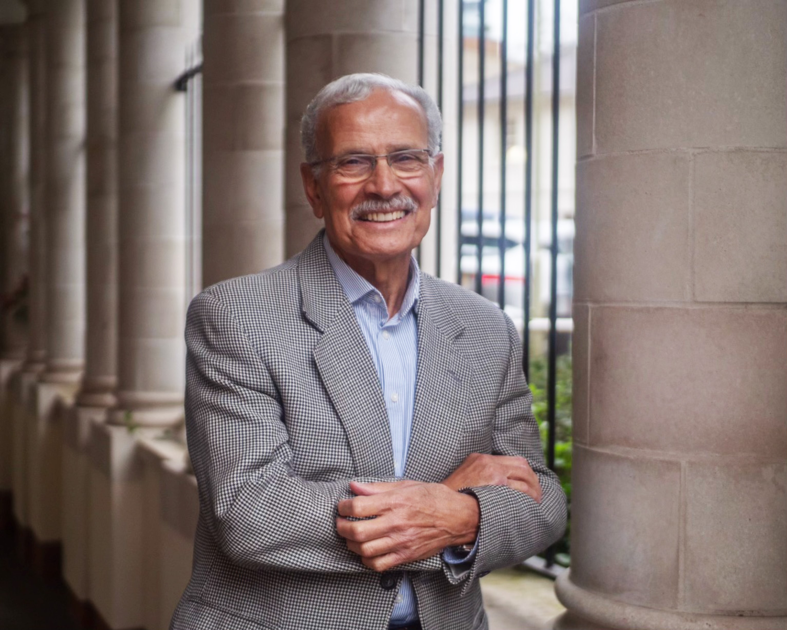 Older Asian man with grey hair and moustache and glasses