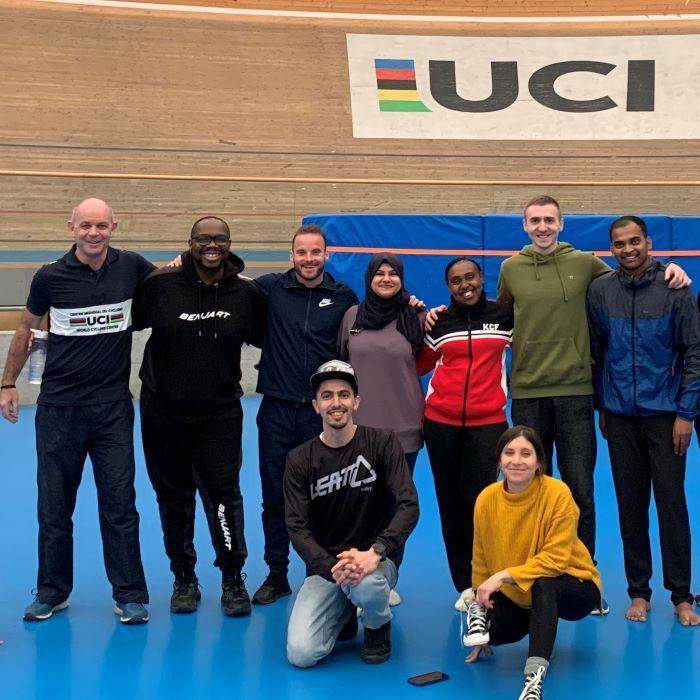 Line up of sports coaches in front of UCI sign