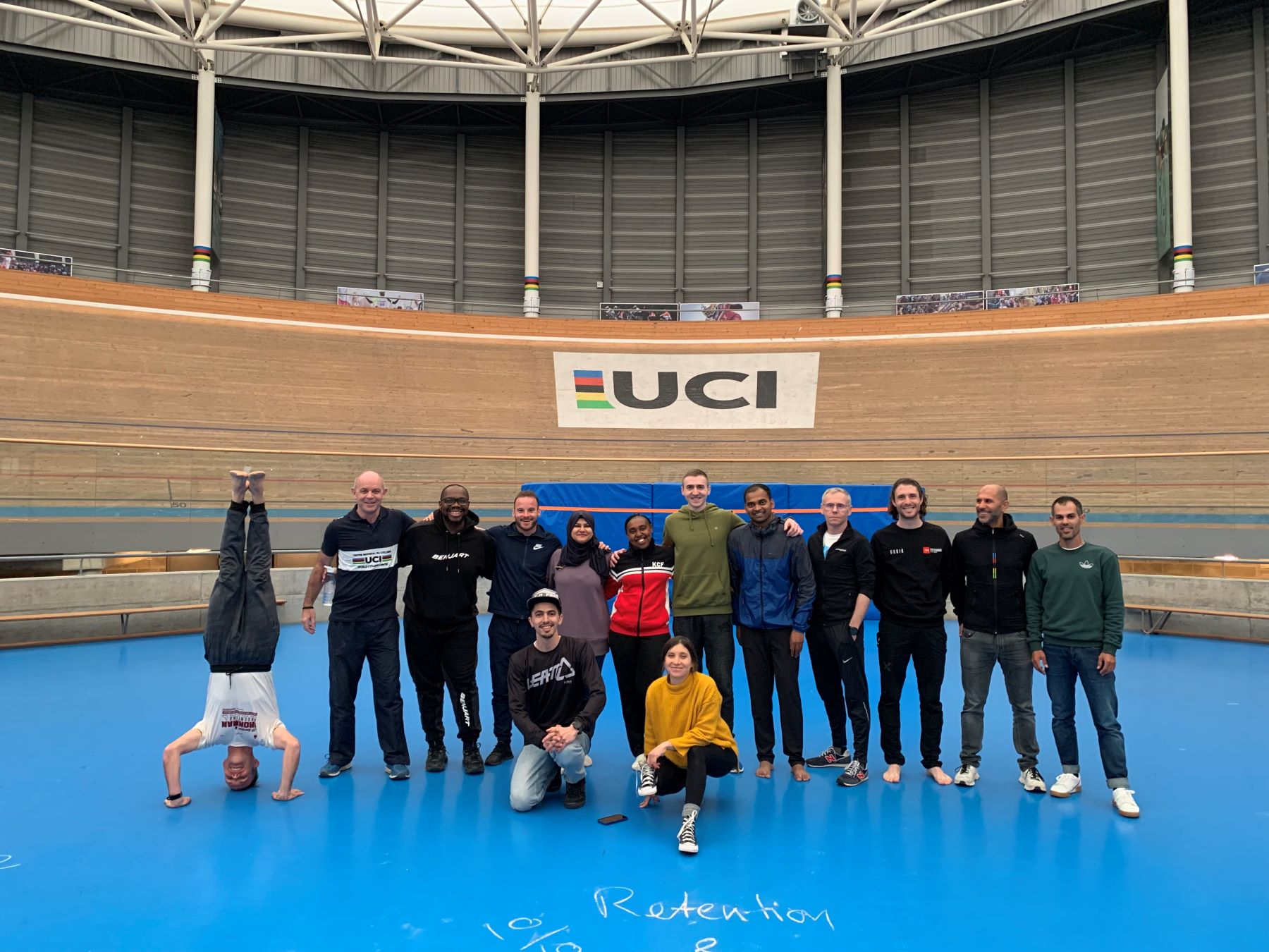 Line up of sports coaches in front of UCI sign