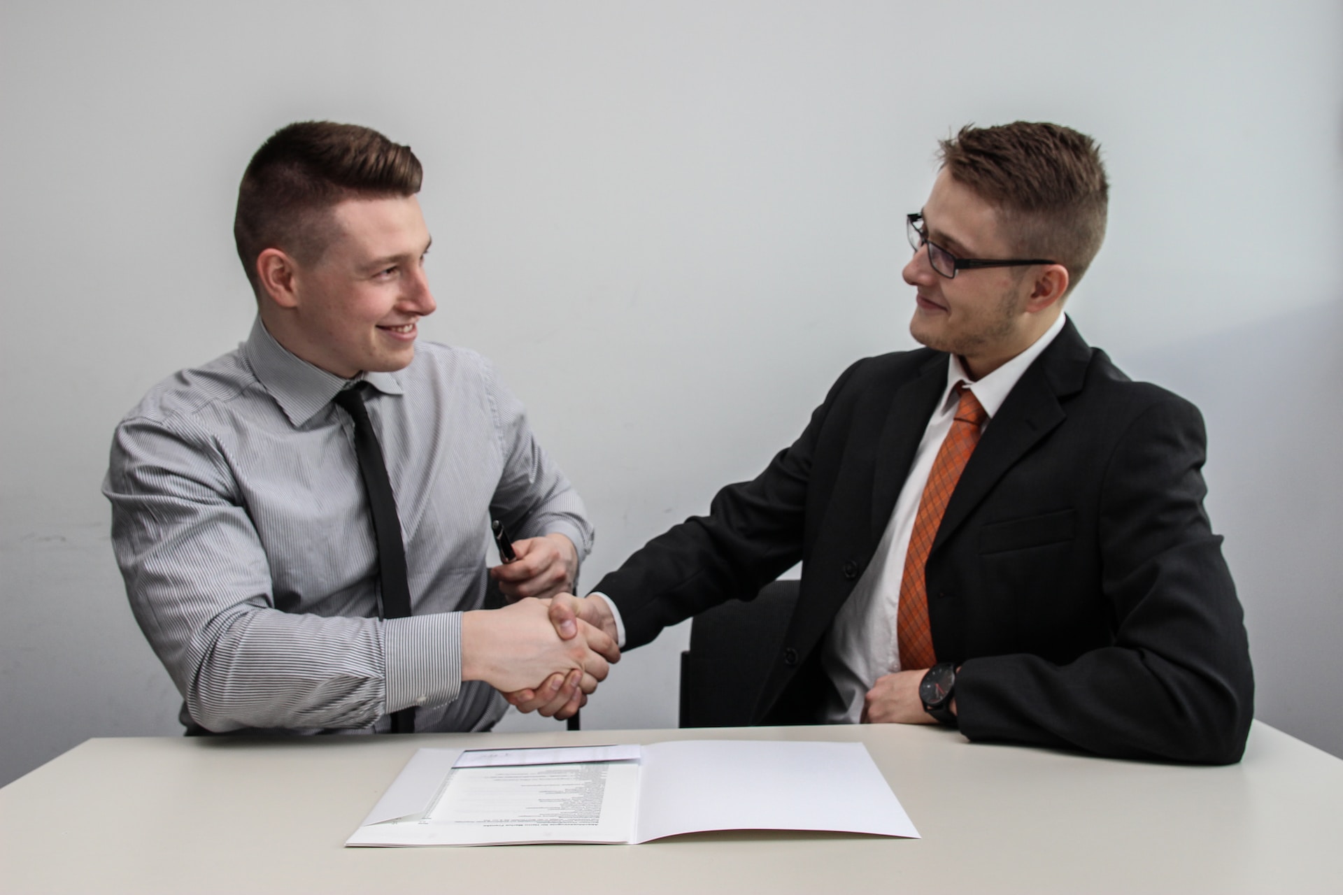 Two young businessmen shaking hands