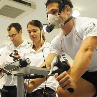 Research and knowledge exchange facilities in Health and Wellbeing at the University of Winchester: two researchers monitoring a man on a static bike