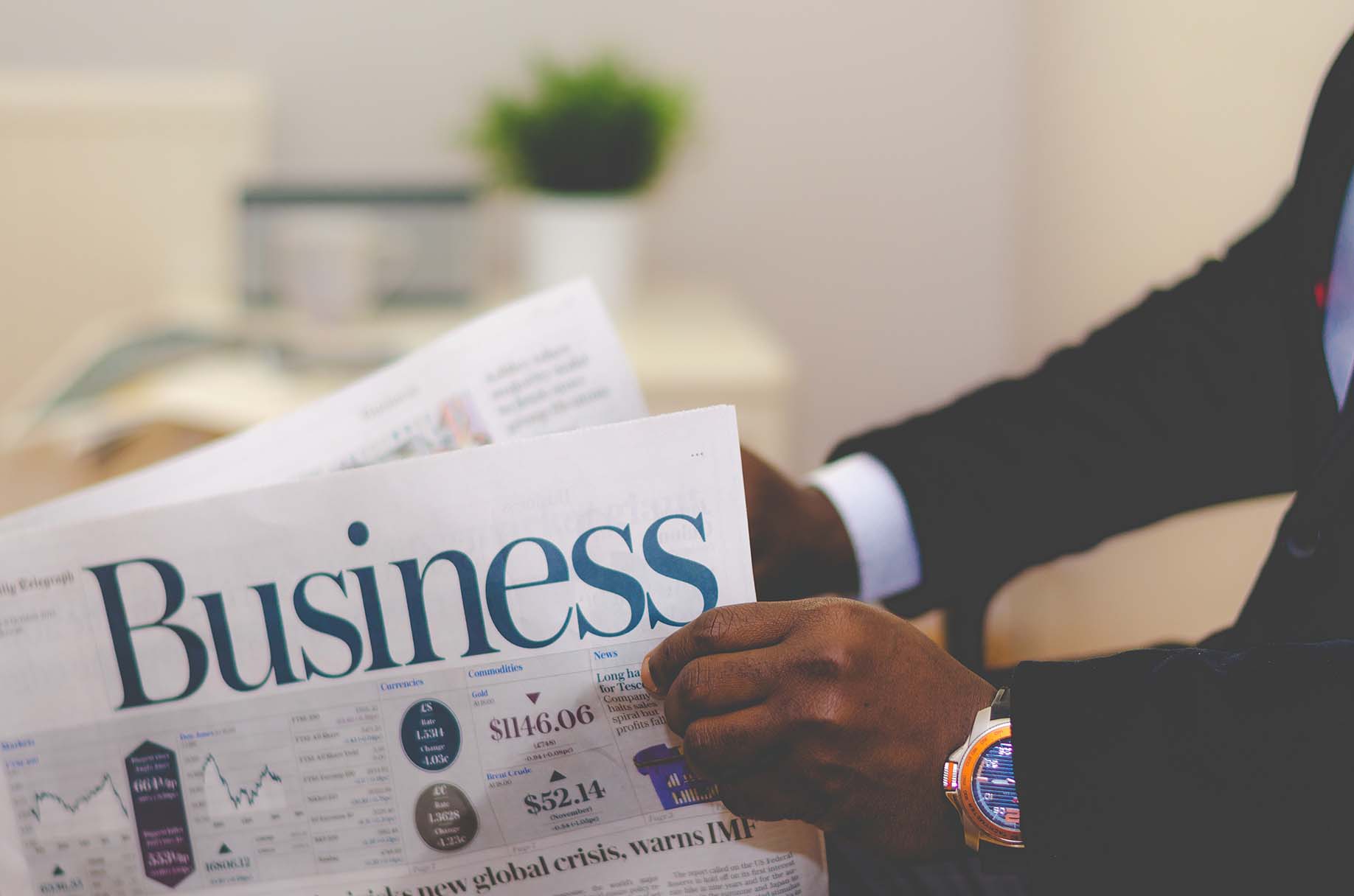 Person reading a newspaper in a suit