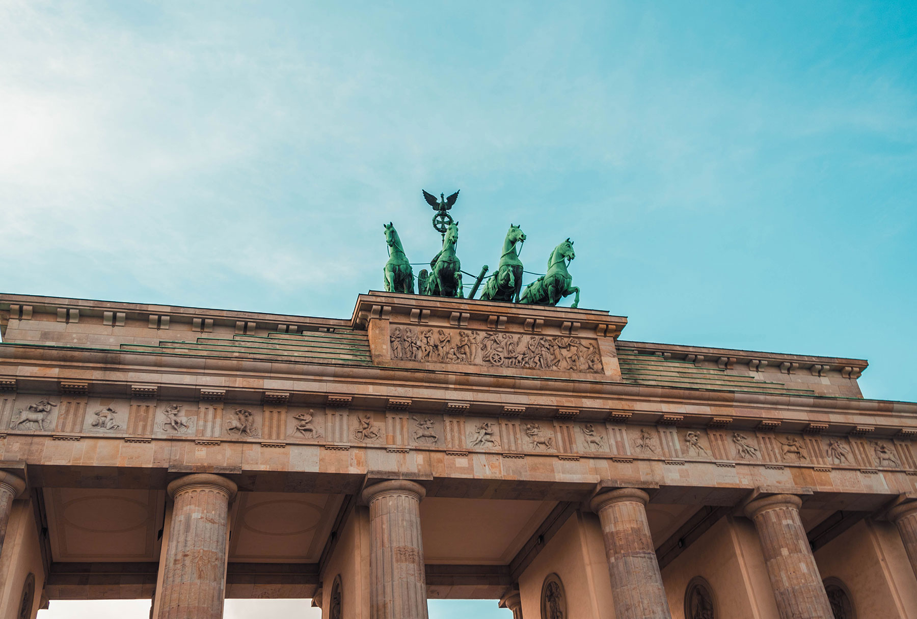 Top of an archway with a statue of four green horses