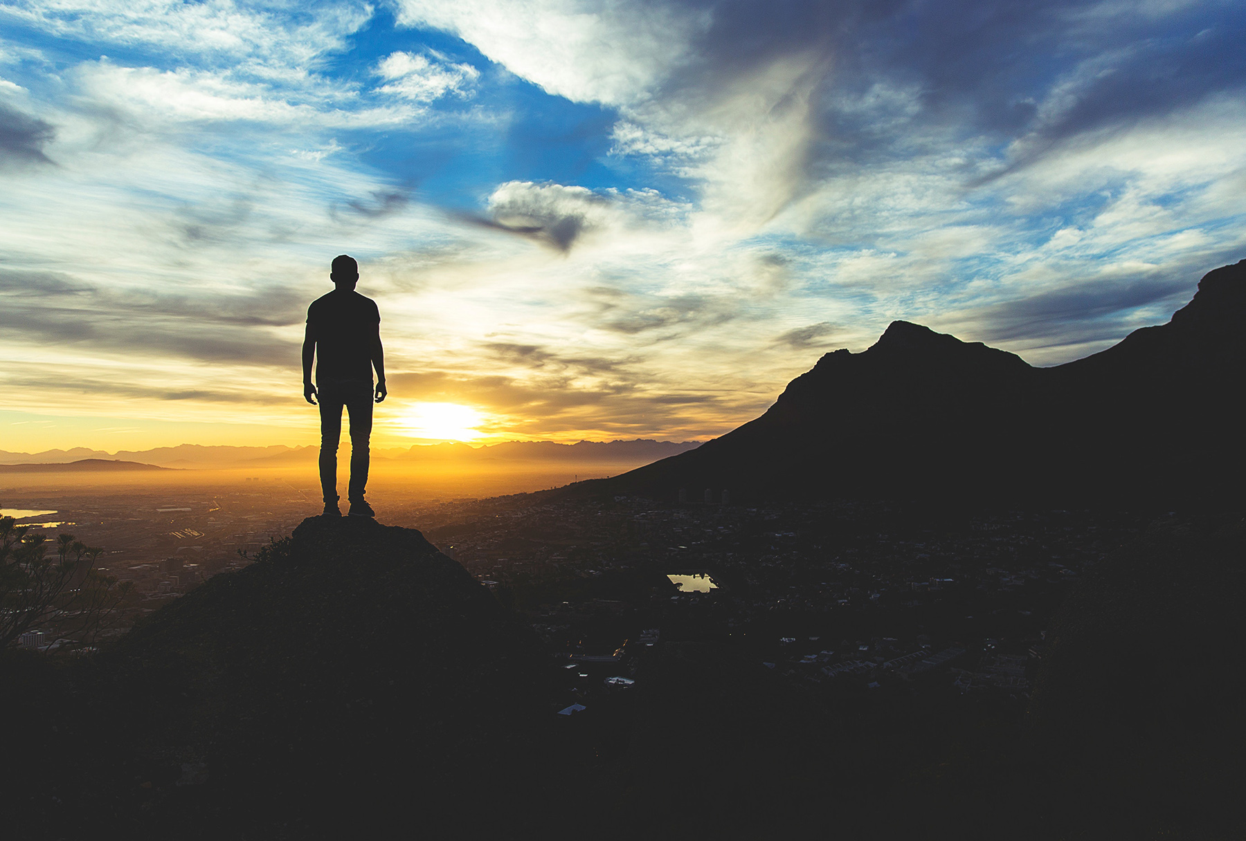 Person on a mountain looking out to the sunset