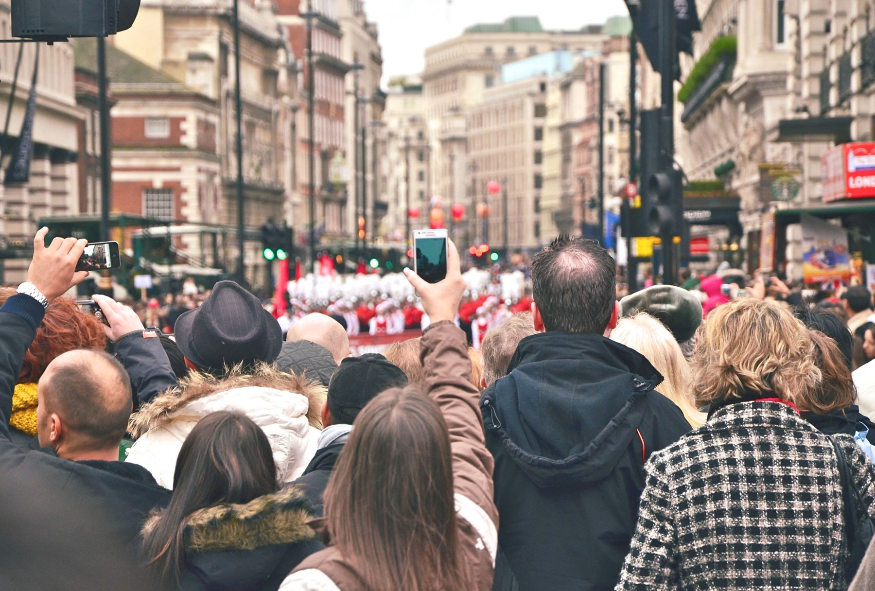 A crowd videoing a parade