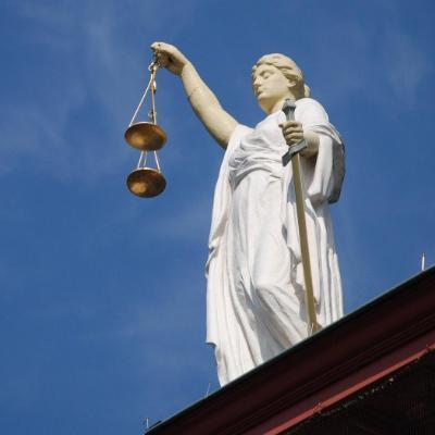 Statue of Lady Justice on the roof a law court against blue sky