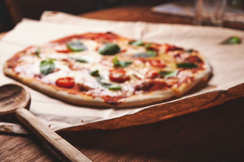 A cooked pizza on baking paper