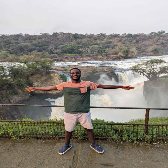 Thomas Bwambale Muhiwa at waterfall in national park in Uganda