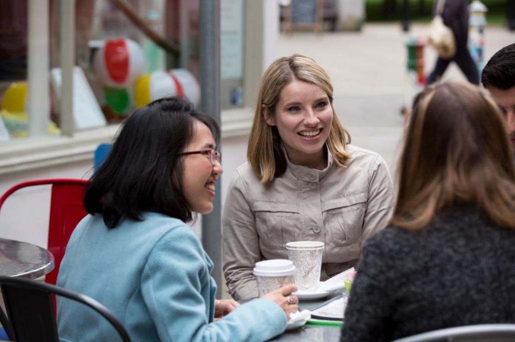 Group of female students drinking coffee at an outdoor table