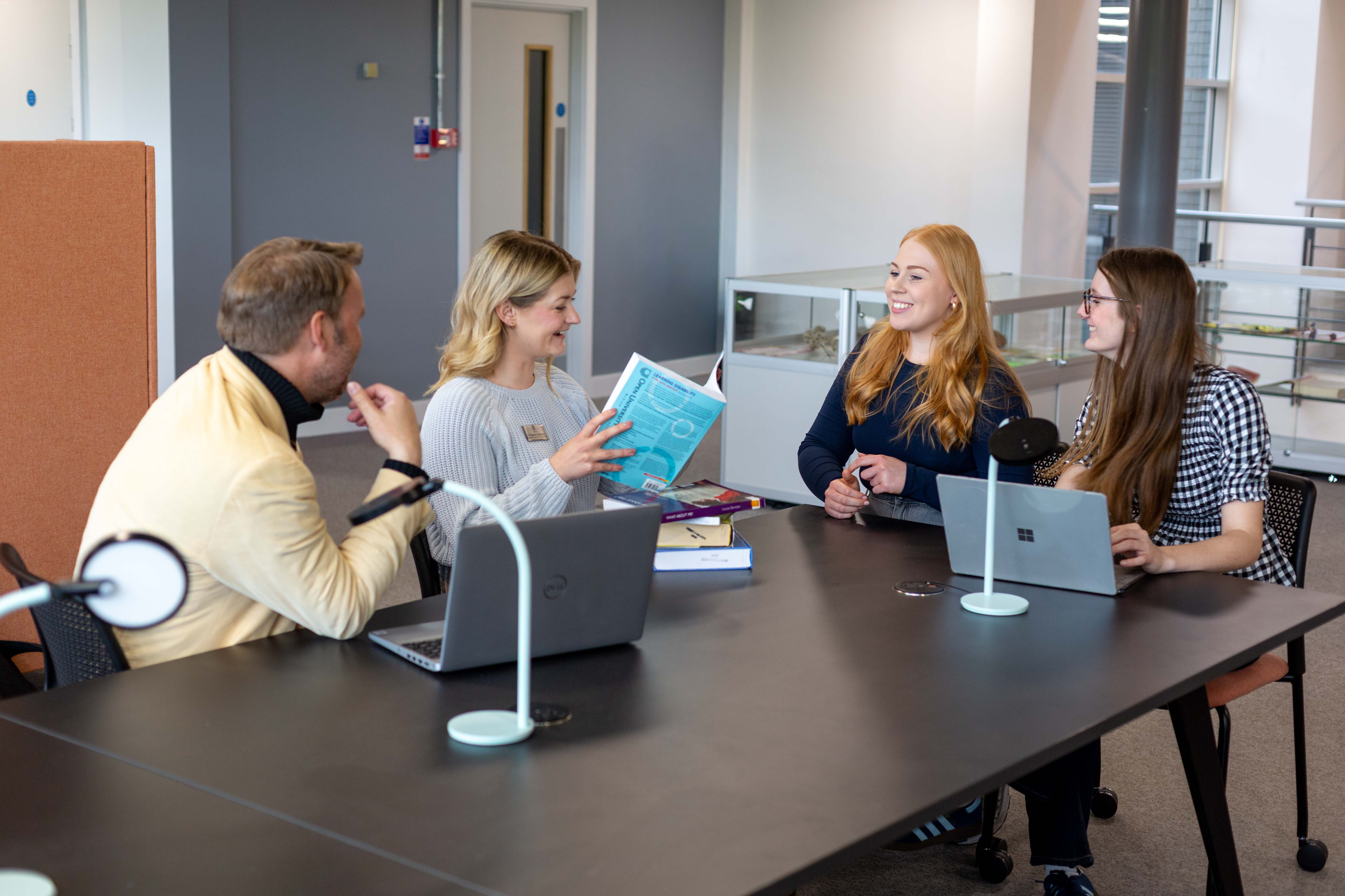 Students talking with academic staff in the University library
