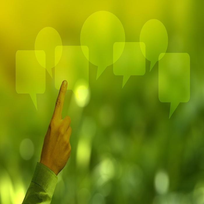 A hand pointing to multiple speech bubbles on a green background