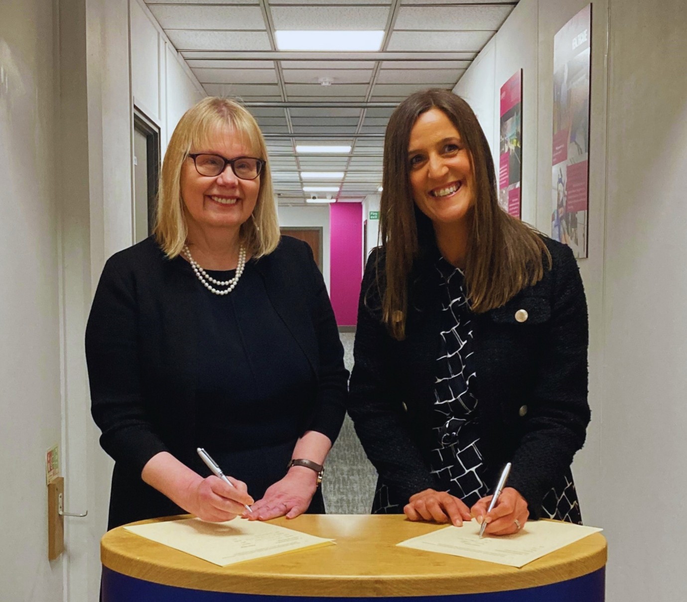 Professor Sarah Greer CBE, Vice-Chancellor, University of Winchester; Julie Milburn, Principal and Chief Executive Officer, Sparsholt College Group sign a document together