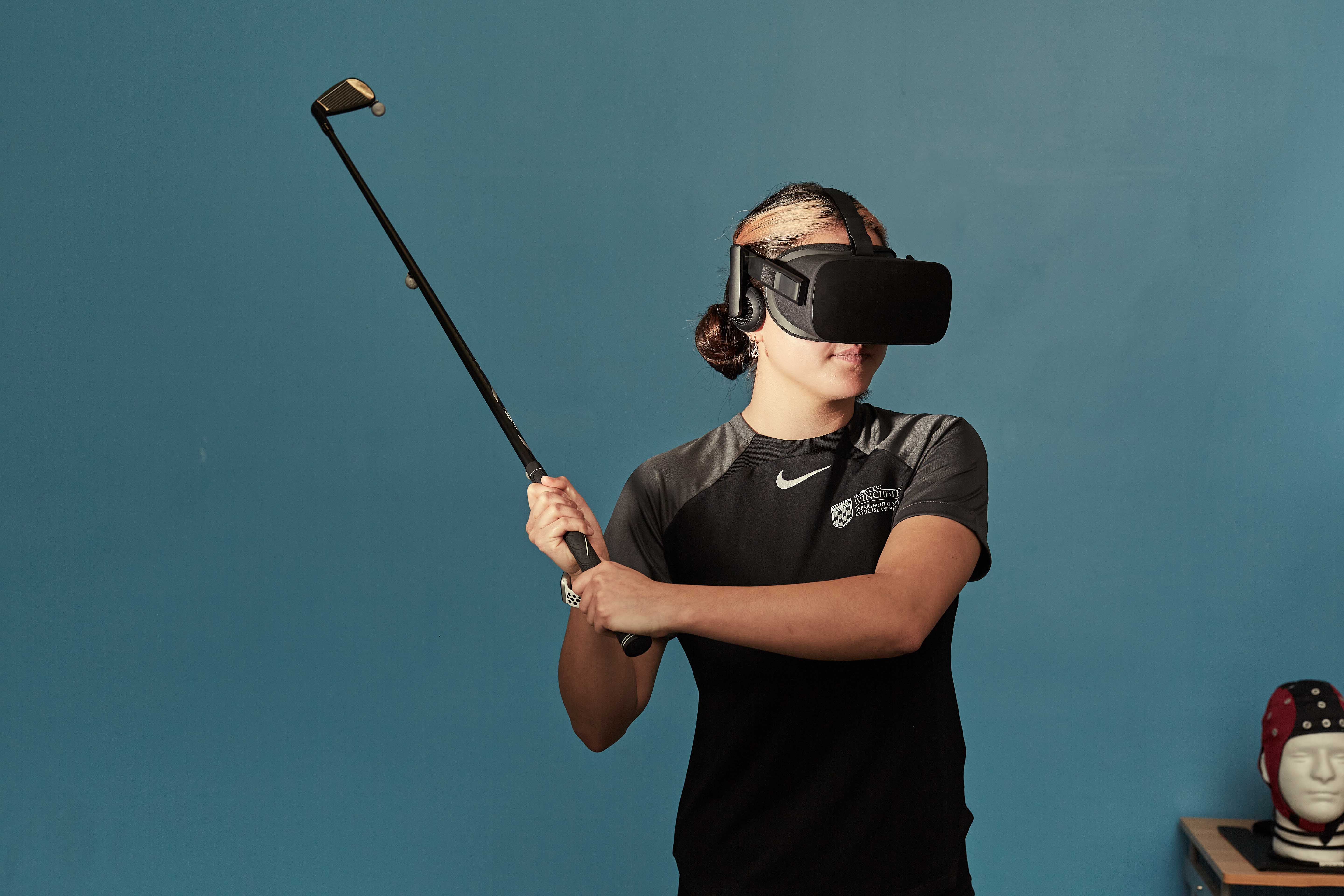 A student uses a VR golf simulator