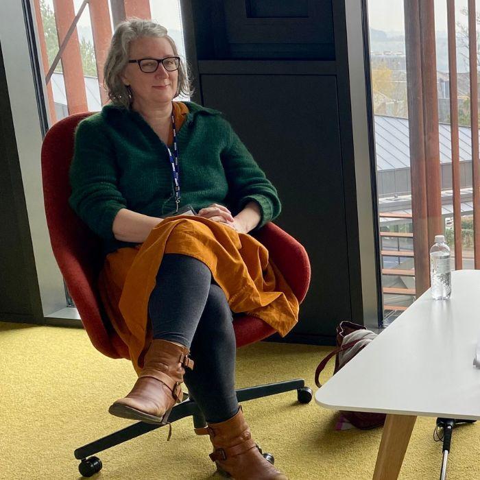 Alumna Clare Fuller and student Eden Irving sitting across a table in conversation in the West Downs Centre