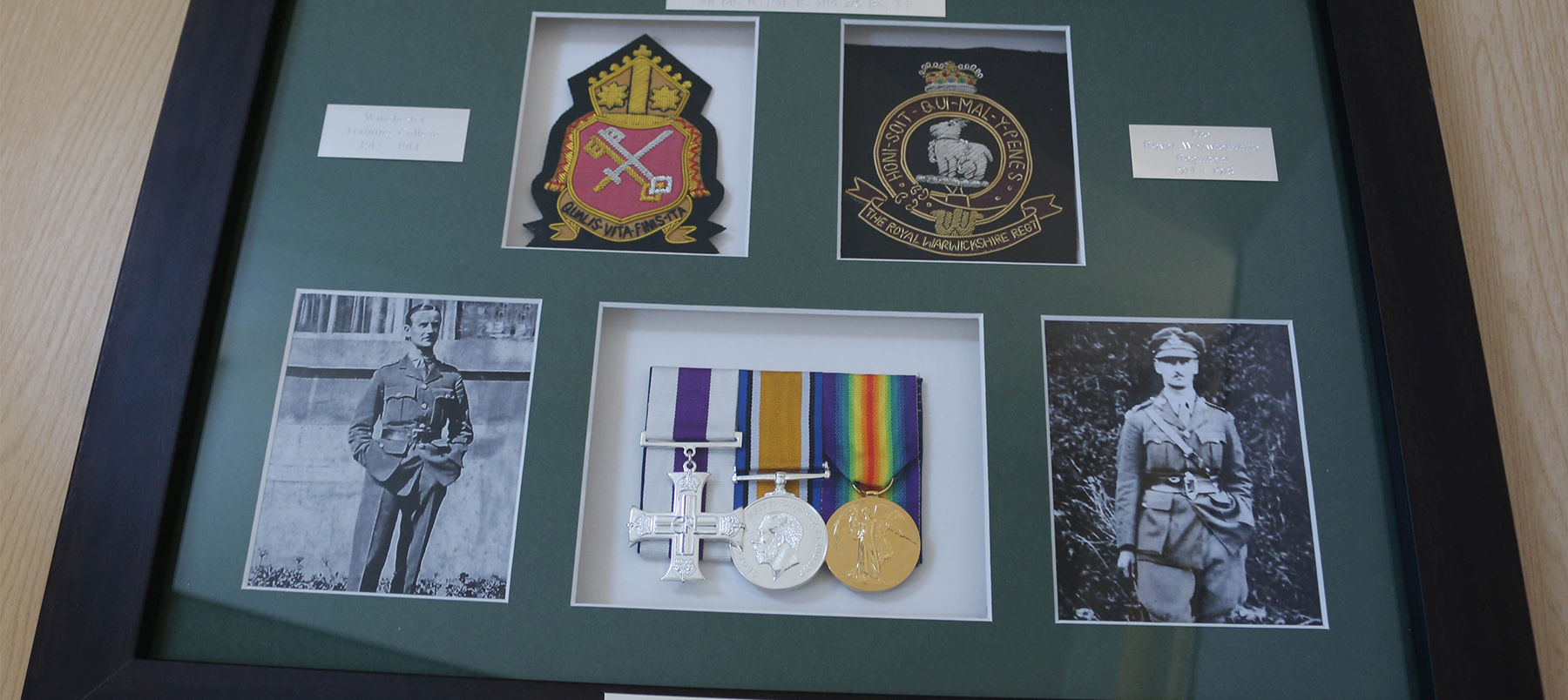Framed presentation of military medals and badges from WWI veteran