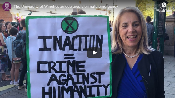 Professor Joy Carter holding a climate change protest banner