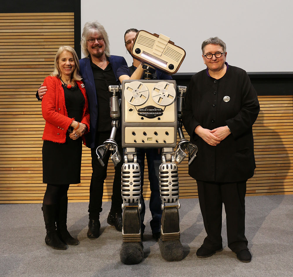 Dirk Maggs posing on stage with Marvin the Paranoid Android 