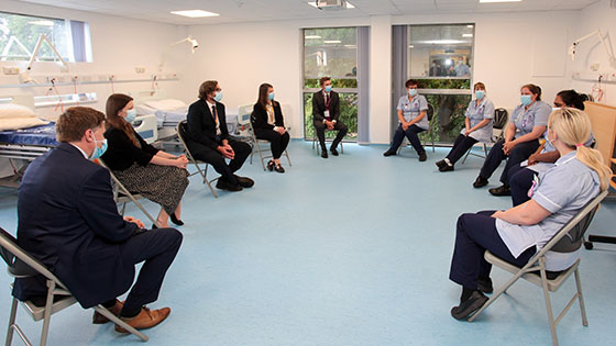 Group of people with nursing students sitting in socially distanced circle