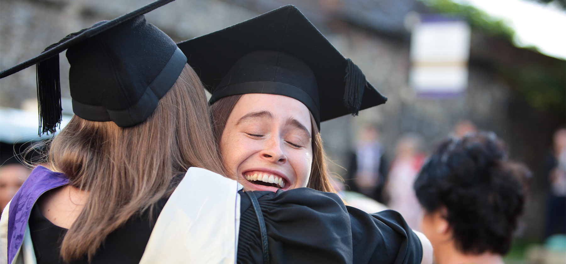 Two female graduates hugging