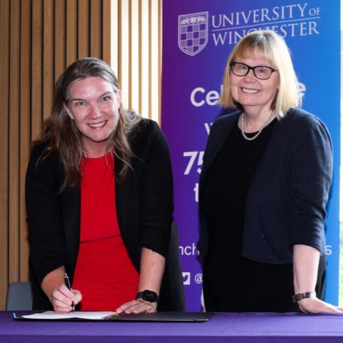 health trust and university staff behind table with university logo