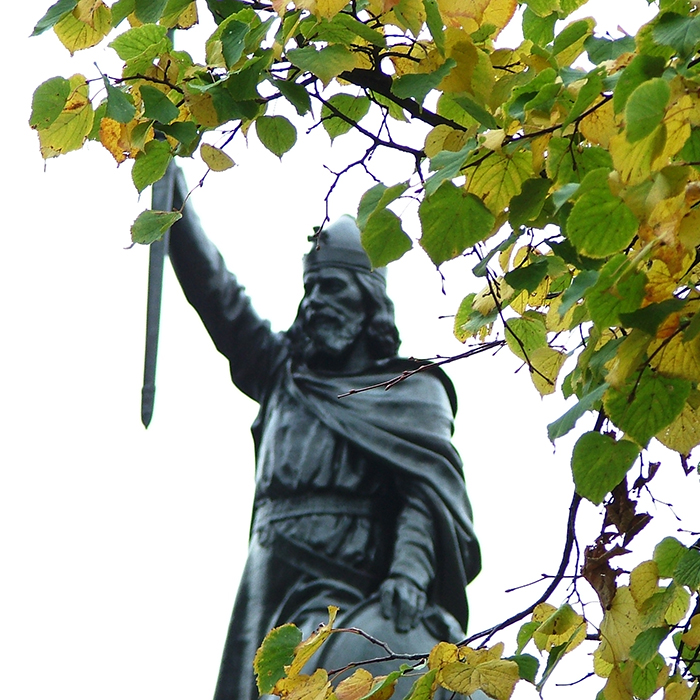 Statue of King Alfred framed by leaves