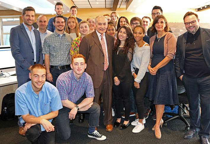 Group of student journalists with Alastair Stewart in newsroom