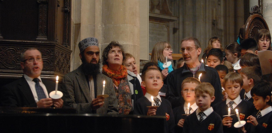 Congregation singing with some holding lighted candles