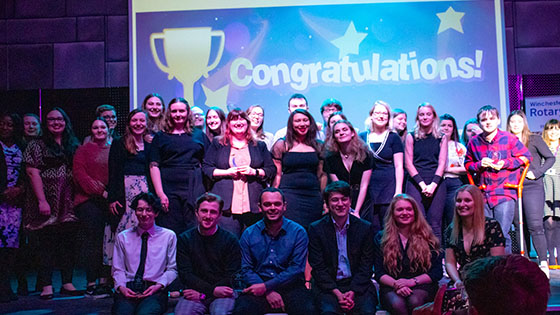 Student volunteers celebrate on stage at awards ceremony