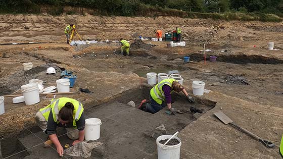 The dig site with archaeologists working