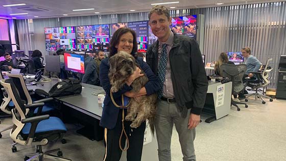 Andrew Knight in TV studio standing next to woman holding a dog