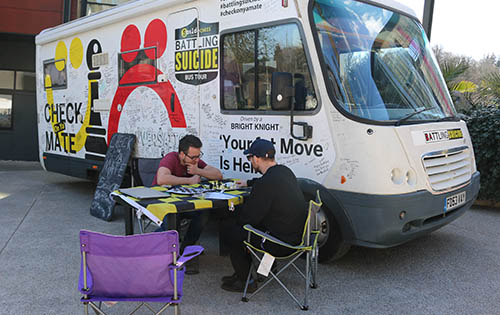 Close up of suicide prevention bus and people playing chess
