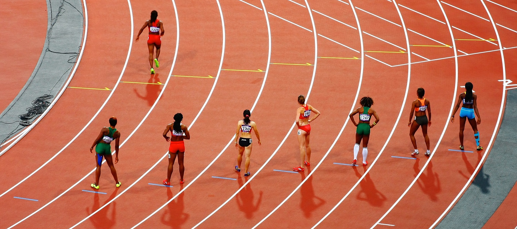 Female athletes on running track waiting to start race