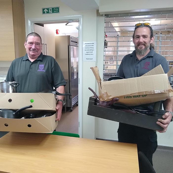 University porters holding boxes of donated kitchen equipment from the bag it up campaign