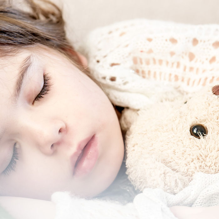 Child asleep with teddy bear 