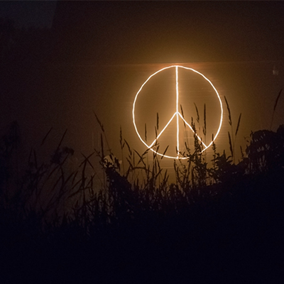 Peace and reconciliation research at Winchester: peace symbol lit up against night sky