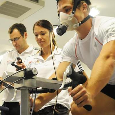 Research and knowledge exchange facilities in Health and Wellbeing at the University of Winchester: two researchers monitoring a man on a static bike