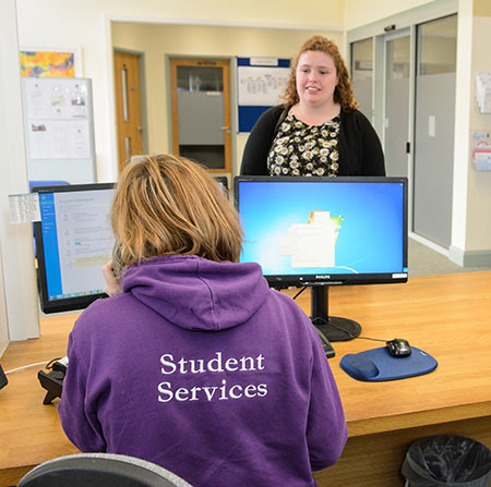 Student services staff member helping a student