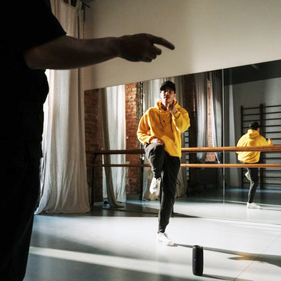 Dance at Winchester: young male dancer in a hoodie in a dance studio with an instructor pointing