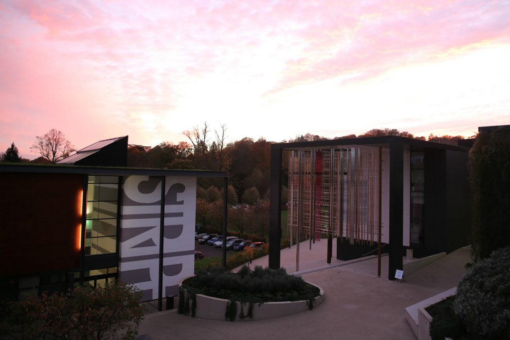 Two buildings on campus at twilight as the sunsets in the sky